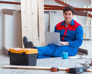 Dizüstü bilgisayarı olan genç bir marangoz