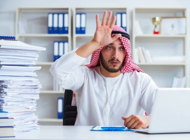 Ofiste çalışan Arap işadamı bir Pi ile evrak işi yapıyor.