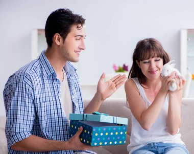 Genç bir kadın doğum günü hediyesi olarak evcil tavşan alıyor.