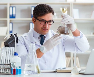 Genç araştırmacı bilim adamı bir su testi kirliliği araştırması yapıyor.