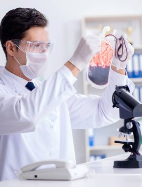 Hastane kliniğinde kan örnekleriyle çalışan bir doktor.