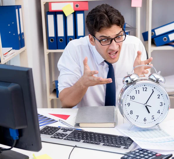 Zakenman werkzaam in het kantoor met stapels boeken en papieren — Stockfoto