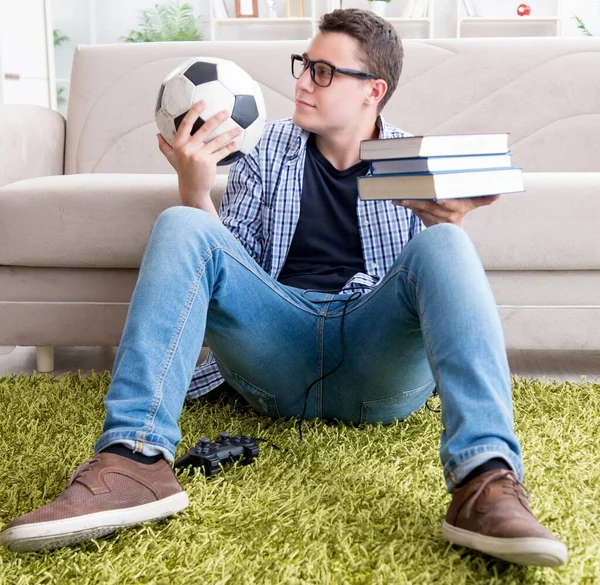 Jovem estudante tentando equilibrar estudar e jogar futebol — Fotografia de Stock