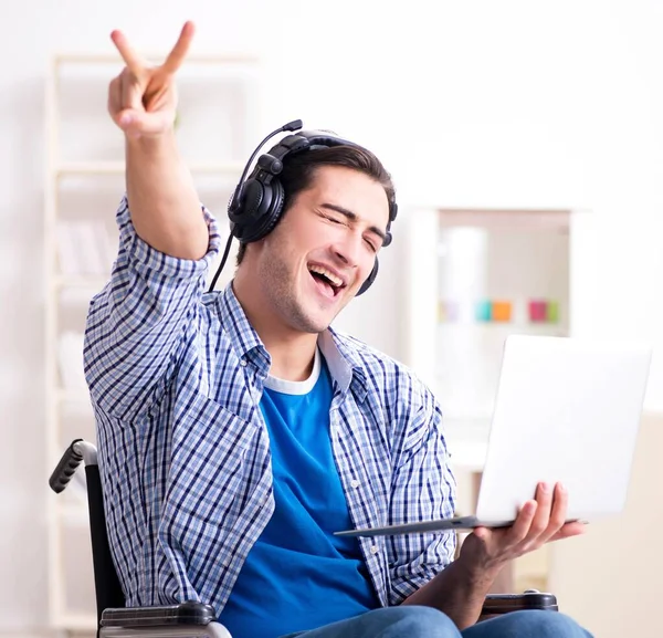Zdravotně postižený muž poslouchá hudbu na invalidním vozíku — Stock fotografie