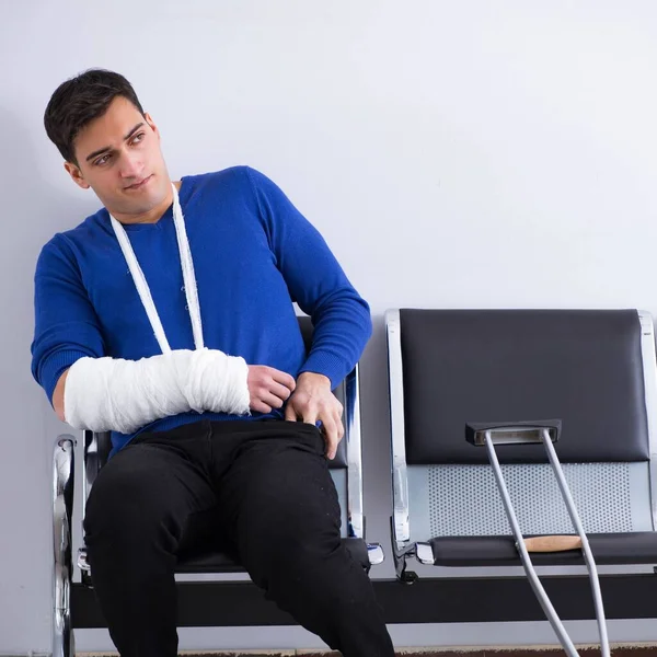 Hombre desesperado esperando su cita en el hospital con la fractura — Foto de Stock