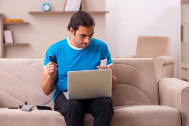 Spor bahsi bağımlısı genç adam evde bahis oynuyor.