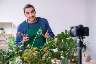 Evin içinde bitkileri olan genç bir erkek bahçıvan.