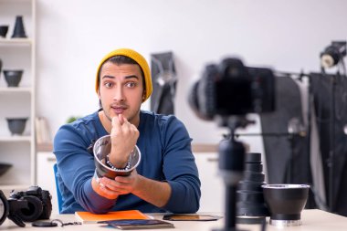 Genç erkek fotoğrafçı bloğu için video kaydediyor.