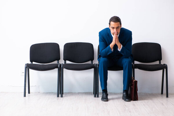 Young businessman waiting for an interview at hall