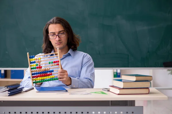 Jonge mannelijke leraar in de voorkant van groene boord — Stockfoto