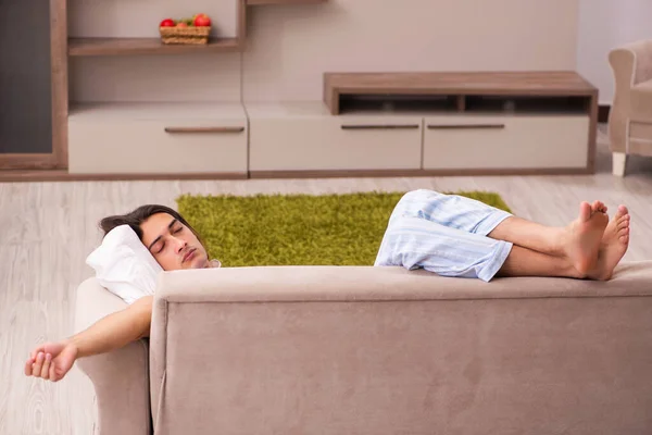 Giovane uomo pigro nel concetto di dormire troppo a casa — Foto Stock