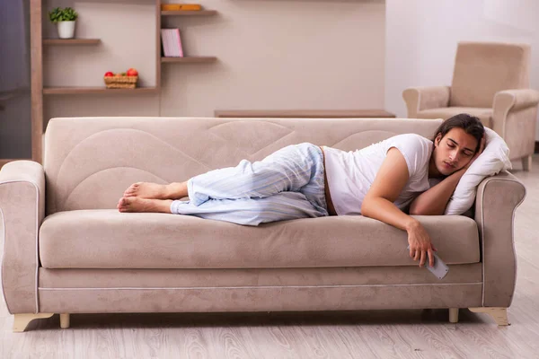 Jovem preguiçoso no conceito de dormir demais em casa — Fotografia de Stock