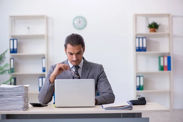 Jovem funcionário masculino infeliz com excesso de trabalho no escritório — Fotografia de Stock