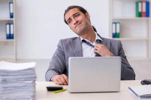 Joven empleado masculino descontento con el trabajo excesivo en la oficina —  Fotos de Stock