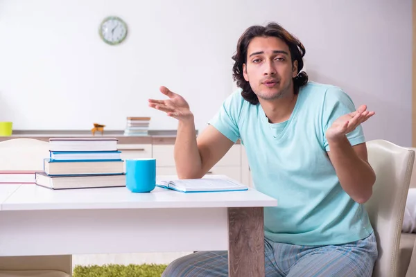 Young male student unhappy with excessive work at home