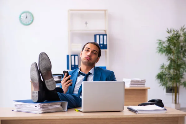 Joven empleado masculino y demasiados trabajan en la oficina —  Fotos de Stock