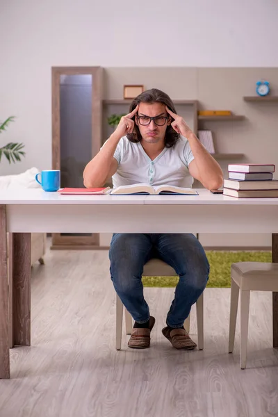 Giovane studente maschio preparazione per gli esami a casa — Foto Stock