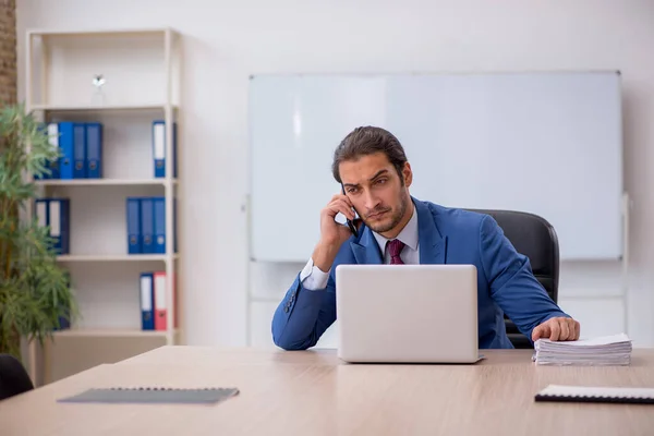 Junge männliche Mitarbeiter sitzen im Büro vor Whiteboard — Stockfoto