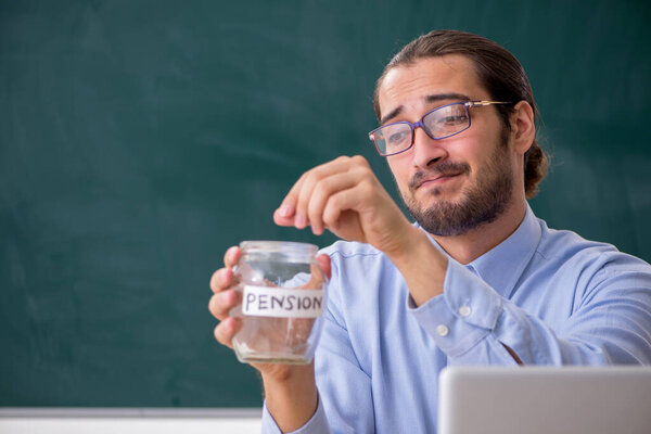 Young underpaid male teacher in the classroom