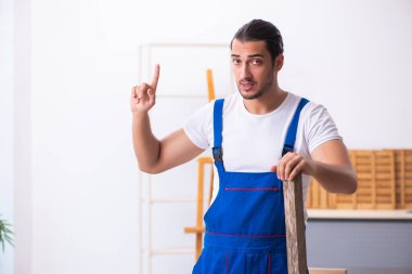 Genç erkek müteahhit atölyede çalışıyor.