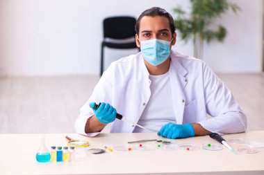 Salgın sırasında laboratuvarda çalışan genç bir kimyager.