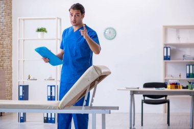 Genç erkek doktor hastanede not alıyor.