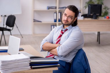 Genç bir erkek işçi aşırı işten memnun değil.