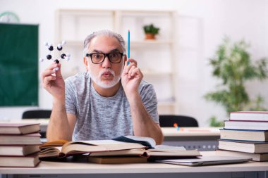 Sınıftaki yaşlı erkek fizikçi.