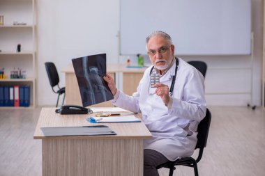 Klinikte çalışan yaşlı bir erkek radyolog.