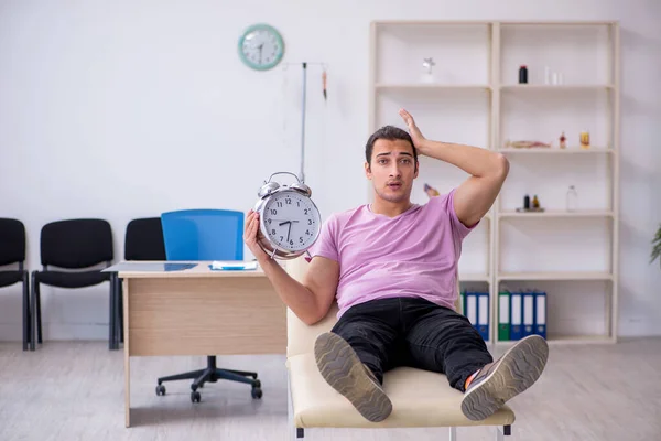 Paciente masculino joven que espera al médico en el concepto de gestión del tiempo — Foto de Stock