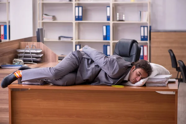 Молодий чоловік працівник спить на робочому місці — стокове фото