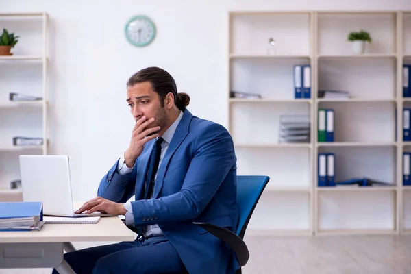 Joven empleado masculino que trabaja en el lugar de trabajo — Foto de Stock