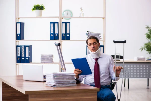 Perna ferido empregado masculino com muletas no local de trabalho — Fotografia de Stock