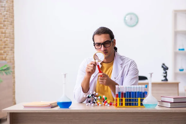 Jonge mannelijke scheikundige student in de klas — Stockfoto