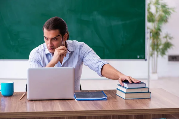 Young male teacher in front of blackboard — Stock Photo, Image