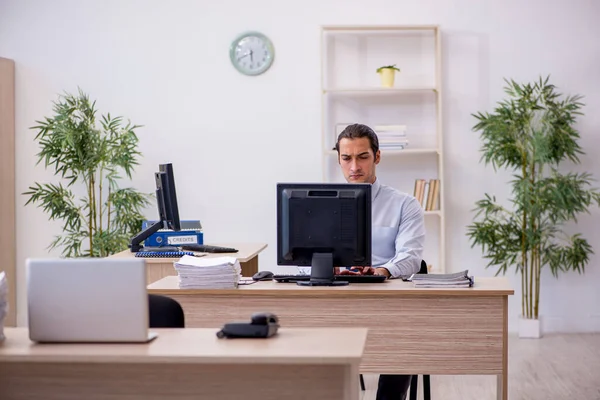Mladý muž zaměstnanec sedí v kanceláři — Stock fotografie