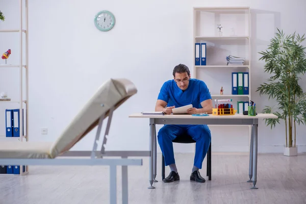 Joven doctor tomando notas en el hospital — Foto de Stock