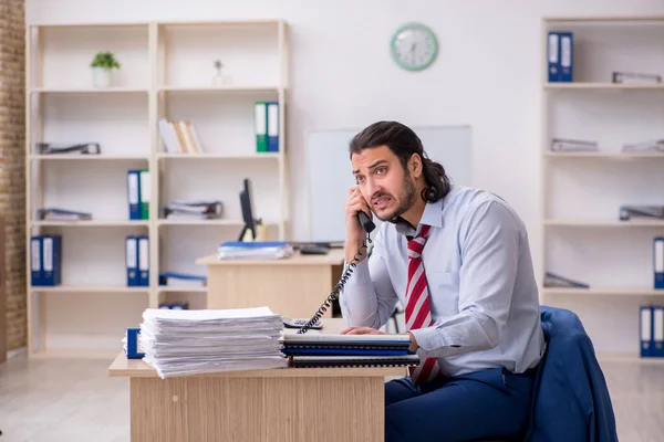 Jeune employé masculin malheureux avec un travail excessif — Photo