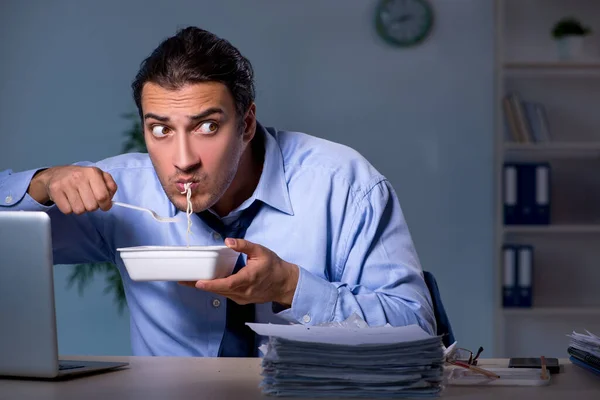 Funcionário com fome trabalhando até tarde no escritório — Fotografia de Stock