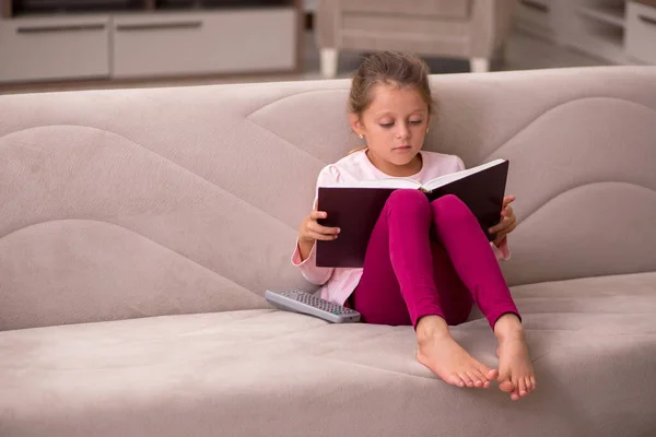 Klein meisje lezen boek thuis — Stockfoto