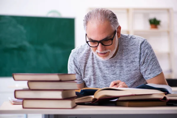 Old male student preparing for exams in the classroom — Stock Photo, Image