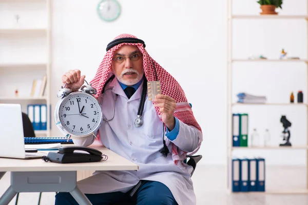 Old male arab doctor in time management concept — Stock Photo, Image