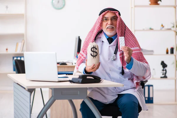 Gammal arab läkare hålla penningpåse — Stockfoto