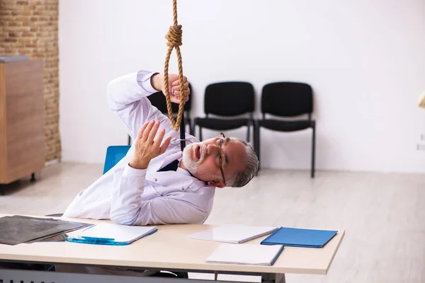 Viejo médico suicidándose en el lugar de trabajo — Foto de Stock