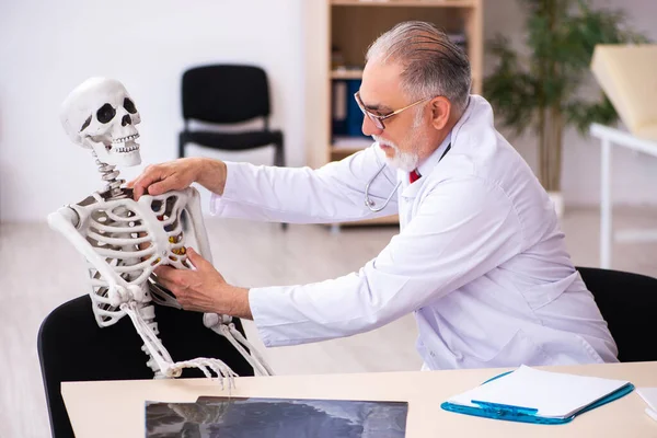 Velho médico cardiologista e paciente esqueleto na clínica — Fotografia de Stock