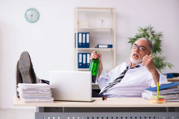 Un vieil employé boit de l'alcool au bureau — Photo