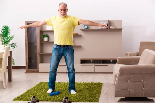 Homme âgé faisant des exercices sportifs à la maison — Photo