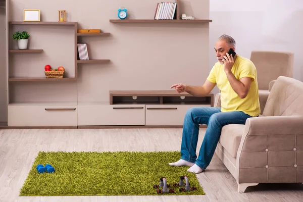 Aged man doing sport exercises at home — Stock Photo, Image