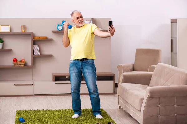 Homme âgé faisant des exercices sportifs à la maison — Photo