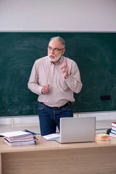 Egy öreg férfi tanár ül az osztályteremben. — Stock Fotó